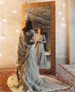 woman in silver dress standing in front of mirror